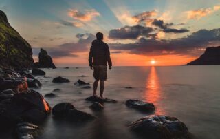 Vivere il Presente - Il Potere del Qui e Ora, spiaggia con uomo al tramonto.